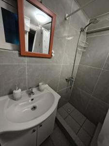 a bathroom with a sink and a shower with a mirror at Cabañas CyG 2 - Chaitén in Chaitén +5 photos