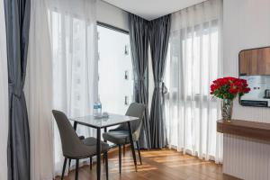 a dining room with a table and chairs and a window at Amora Hotel in Nha Trang