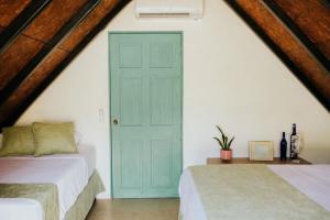a bedroom with two beds and a blue door at Hotel Los Olivos La Playa in Escuintla