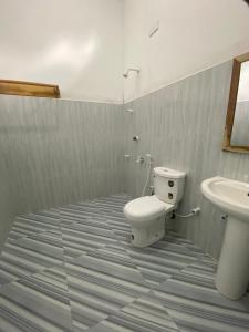 a bathroom with a toilet and a sink at Stay at arugambay in Pottuvil
