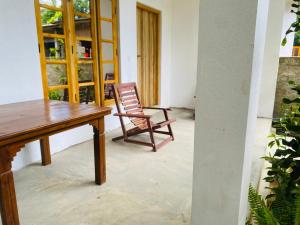 a wooden table and a chair in a room at Stay at arugambay in Pottuvil