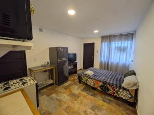 a room with a kitchen with a bed and a refrigerator at Nova Suites in San Juan Xilotzingo +2 photos