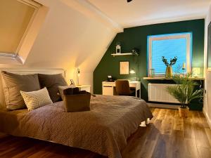 a bedroom with a bed and a green wall at Fewos Herrentor in Emden in Emden