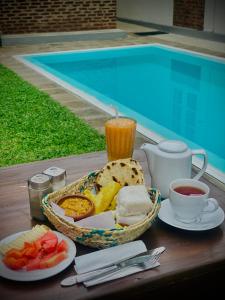 a table with a basket of food and a cup of juice at BnB by Month in Weligama