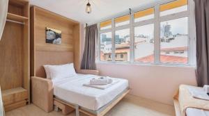 a hotel room with a bed and a window at CoZzzee Hostel in Singapore