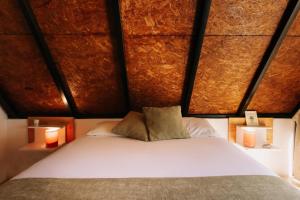 a bedroom with a white bed with two lamps at Hotel Los Olivos La Playa in Escuintla