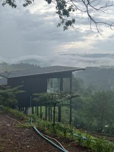 a house on top of a hill with a foggy valley at ไร่ปราณปรียา in Campson