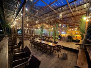 a restaurant with a wooden table and chairs at Sand and Sun Koh Rong in Kaôh Rŭng