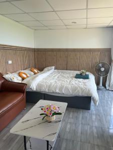 a bedroom with a bed and a coffee table at ไร่ปราณปรียา in Campson