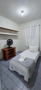 a bedroom with a bed and a wooden table at Casa Cabugi Ponta Negra JR in Natal