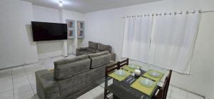 a living room with a couch and a table at Casa Cabugi Ponta Negra JR in Natal