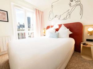 ein Schlafzimmer mit einem weißen Bett und einem Fenster in der Unterkunft Mercure Paris Montparnasse Raspail in Paris
