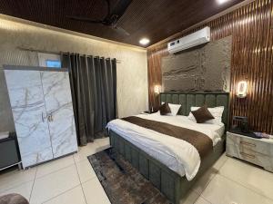 a bedroom with a large bed and a projection screen at Hotel Maheshwari Tehri in Tehri-Garhwāl