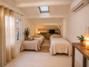 a room with three beds and a living room at La Maison de Verdun in Sainte-Maxime