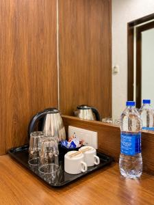 a tray with glasses and a bottle of water on a counter at Cosset - A Boutique Hotel in Lonavala