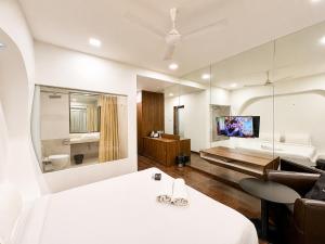 a hotel room with a bed and a living room at Cosset - A Boutique Hotel in Lonavala