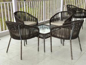 a group of chairs and a glass table on a porch at Hotel Maheshwari Tehri in Tehri-Garhwāl