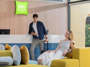 a man standing next to a woman in a waiting room at ibis Styles Phuket Bangtao in Bang Tao Beach