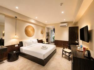 a hotel room with a bed and a television at HemTouch House - Nguyễn Văn Mai in Ho Chi Minh City