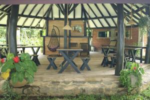 a patio with picnic tables and benches in a pavilion at Aji fruit farm cottage peaceful lakeside farm stay with sunrise views 01 in Embilipitiya