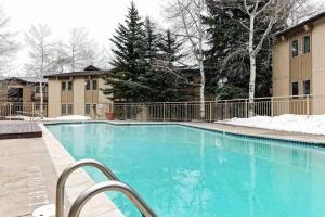 a large blue swimming pool in front of a building at Snowmass Village 14A in Snowmass Village