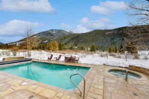 a swimming pool with snow covered mountains in the background at Red Hawk Lodge 2200 in Dillon