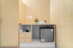 a shelf with a small refrigerator in a room at Aby Guest House in Sidemen