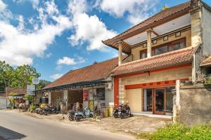 a building with motorcycles parked outside of it at Aby Guest House in Sidemen