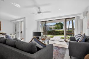 a living room with two couches and a view of a patio at The Noosa Apartments in Noosa Heads
