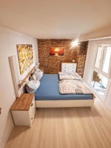 a bedroom with a bed and a brick wall at Casa Anno 1782 in Markdorf