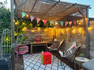 a patio with chairs and a table and lights at La Villa d'ElodibiZa, 45mn de Paris en train avec piscine ! in Écuelles