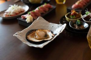 a bowl of food on a table with other plates of food at 金木犀 in Kesennuma