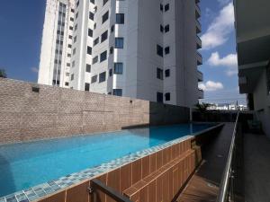 a swimming pool in front of a tall building at Apartamento in Pereira