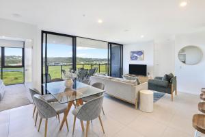 a living room with a glass table and chairs at Alcyone at The Corso in Maroochydore