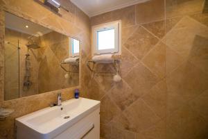 a bathroom with a sink and a mirror at Poolside Bar Villa Sea Views atalky in Klepini +35 photos
