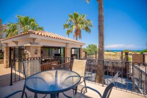 a table and chairs on a balcony with a gazebo at Poolside Bar Villa Sea Views atalky in Klepini
