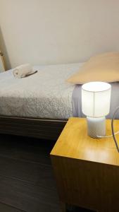 a bedroom with a bed with a lamp on a table at Encanto junto al lago en la zona viva in San Pedro La Laguna