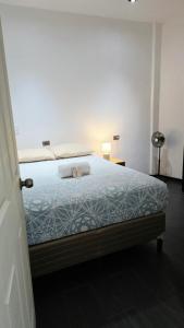 a bedroom with a bed with a blue comforter at Encanto junto al lago en la zona viva in San Pedro La Laguna