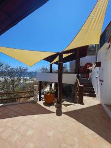 ein großer gelber Sonnenschirm auf dem Dach einer Terrasse in der Unterkunft Milky Way in San Miguel del Puerto + 3 Fotos