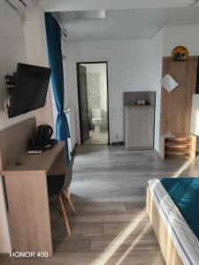 a room with a desk and a bed and a bathroom at Casa KIM in Eforie Nord