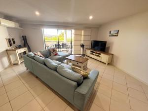 a living room with a couch and a television at Jubilee Apartment 04 - Bring your own linen in South West Rocks