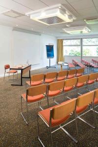 a room with a classroom with chairs and a screen at Novotel Amiens Pôle Jules Verne in Boves +44 photos