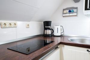 a kitchen counter with a coffee maker and a sink at Möhlenblick in Neustadt in Holstein