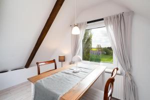 a dining room with a table and a window at Möhlenblick in Neustadt in Holstein