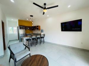 a living room with a table and chairs and a tv on the wall at Casa Bugambilias 3 tercer piso in La Peñita de Jaltemba +5 photos