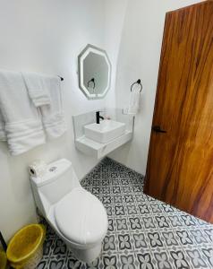 a bathroom with a toilet and a sink and a mirror at Casa Bugambilias 3 tercer piso in La Peñita de Jaltemba