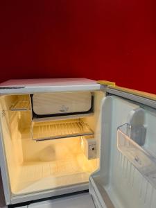 an empty refrigerator with its door open in a room at Sino @ Thungsong in Thung Song