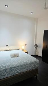 a bedroom with a bed with a blue comforter at Encanto junto al lago en la zona viva in San Pedro La Laguna