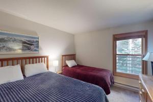 a bedroom with two beds and a window at Snowdance Manor 205 in Keystone +65 photos