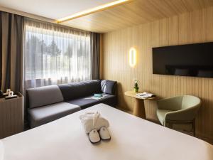 a hotel room with a bed and a couch at Novotel Nancy in Nancy